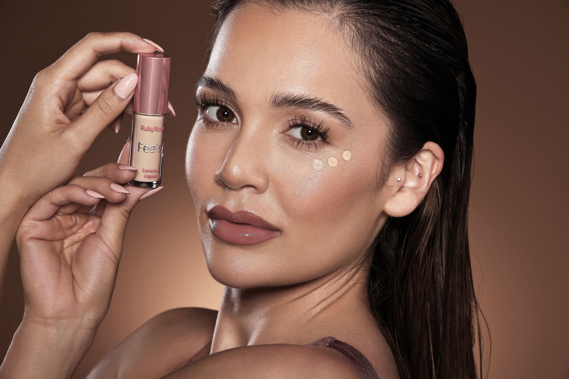 Close-up beauty portrait holding Ruby Rose Feels concealer